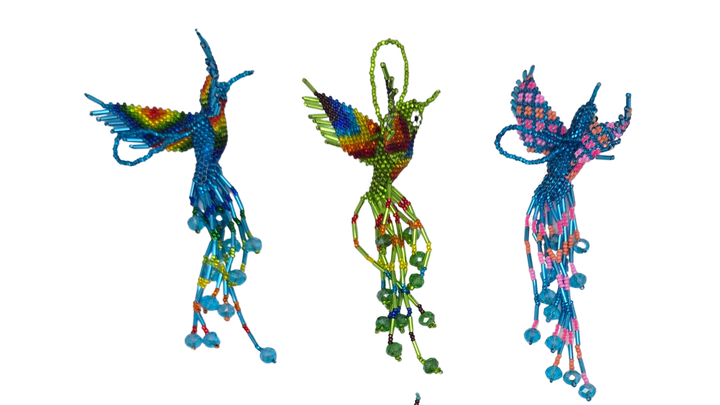 Colorful beaded hummingbird ornaments on a white background

