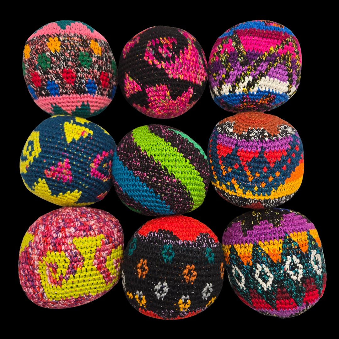 Colorful crocheted balls with geometric patterns on a black background