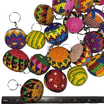 Assorted colorful crocheted hacky sack keychains with a ruler for size reference.
