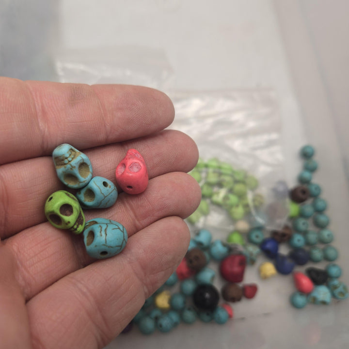 Hand held cluster of small stone skull beads in turquoise, green and coral, drilled, stone skull beads, bulk skull beads
